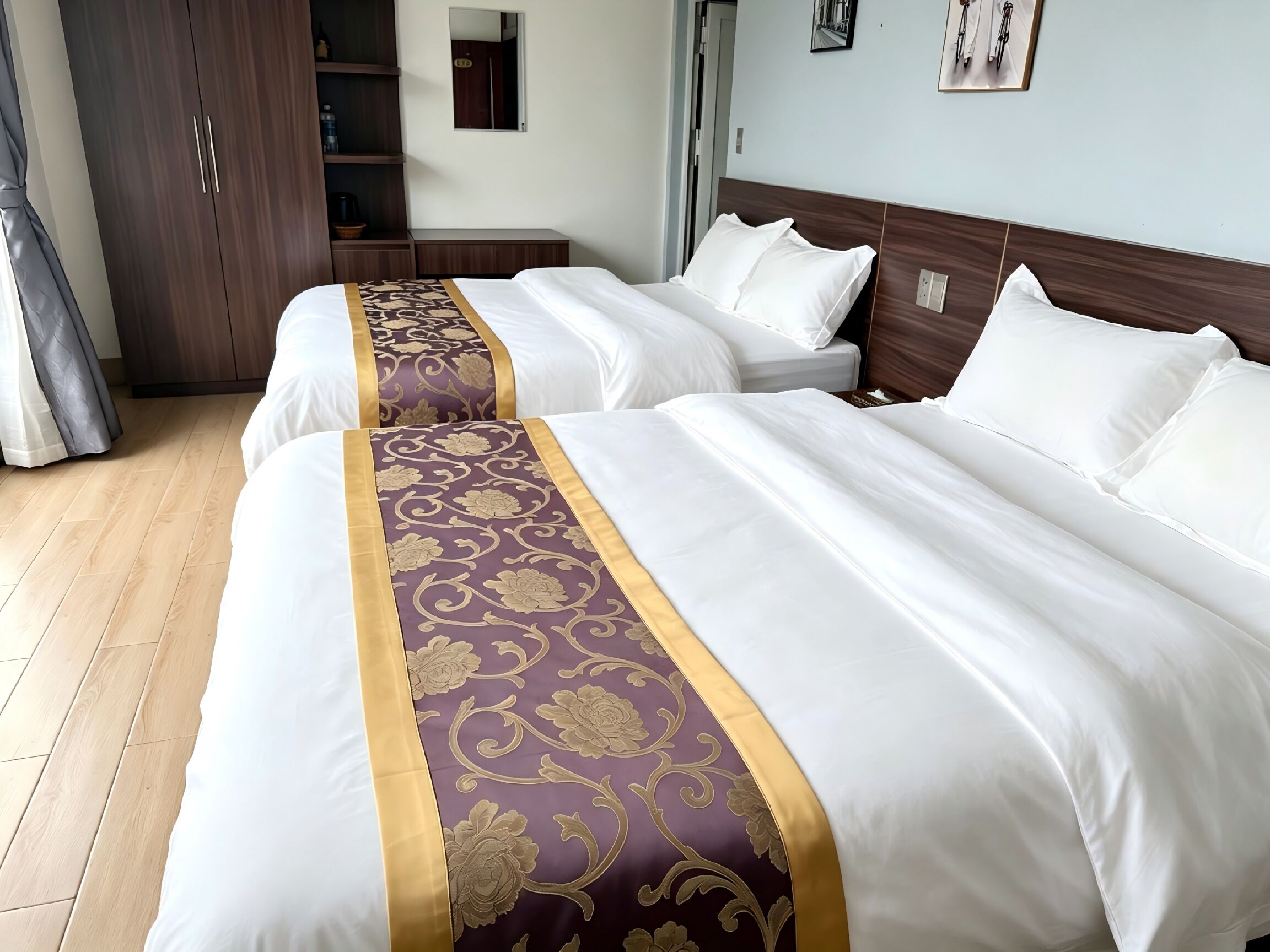 Une chambre d’hôtel avec deux lits, une armoire et une salle de bain.