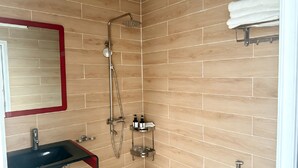Un baño con ducha, lavamanos e inodoro.