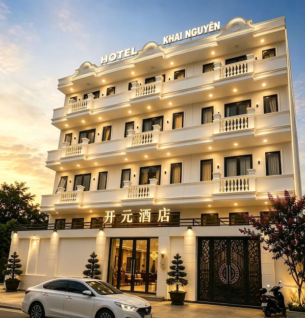 Un hotel de varios pisos con balcones y un letrero que indica que es el KHAI NGUYEN HOTEL.