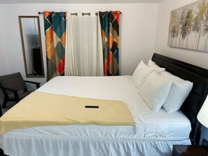 Ein Hotelzimmer mit einem Bett, einem Sessel, einem Spiegel und einem Bild an der Wand.