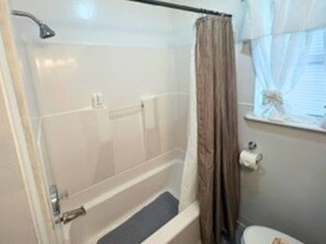 Un bagno con una vasca, una doccia e un water.