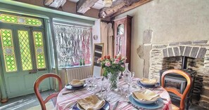 A dining table set with plates, glasses, and a vase of flowers. - Git'zen - LA ROCHE-JAUDY (LA ROCHE-JAUDY)