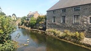 A stone building with a river in front, surrounded by greenery. - Git'zen - LA ROCHE-JAUDY (LA ROCHE-JAUDY)