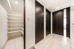 A modern interior with a staircase, dark wooden doors, and a tiled floor. - Morikoya Hotel (Tokyo)