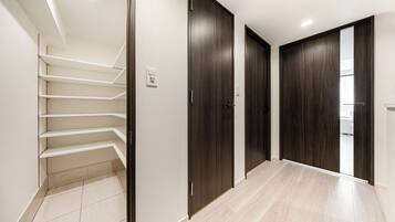A modern interior with a staircase, dark wooden doors, and a tiled floor.