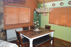 A dining area with a wooden table, chairs, and a chandelier. - Incredible Whispering Pines Escape (Pinetop Country Club)