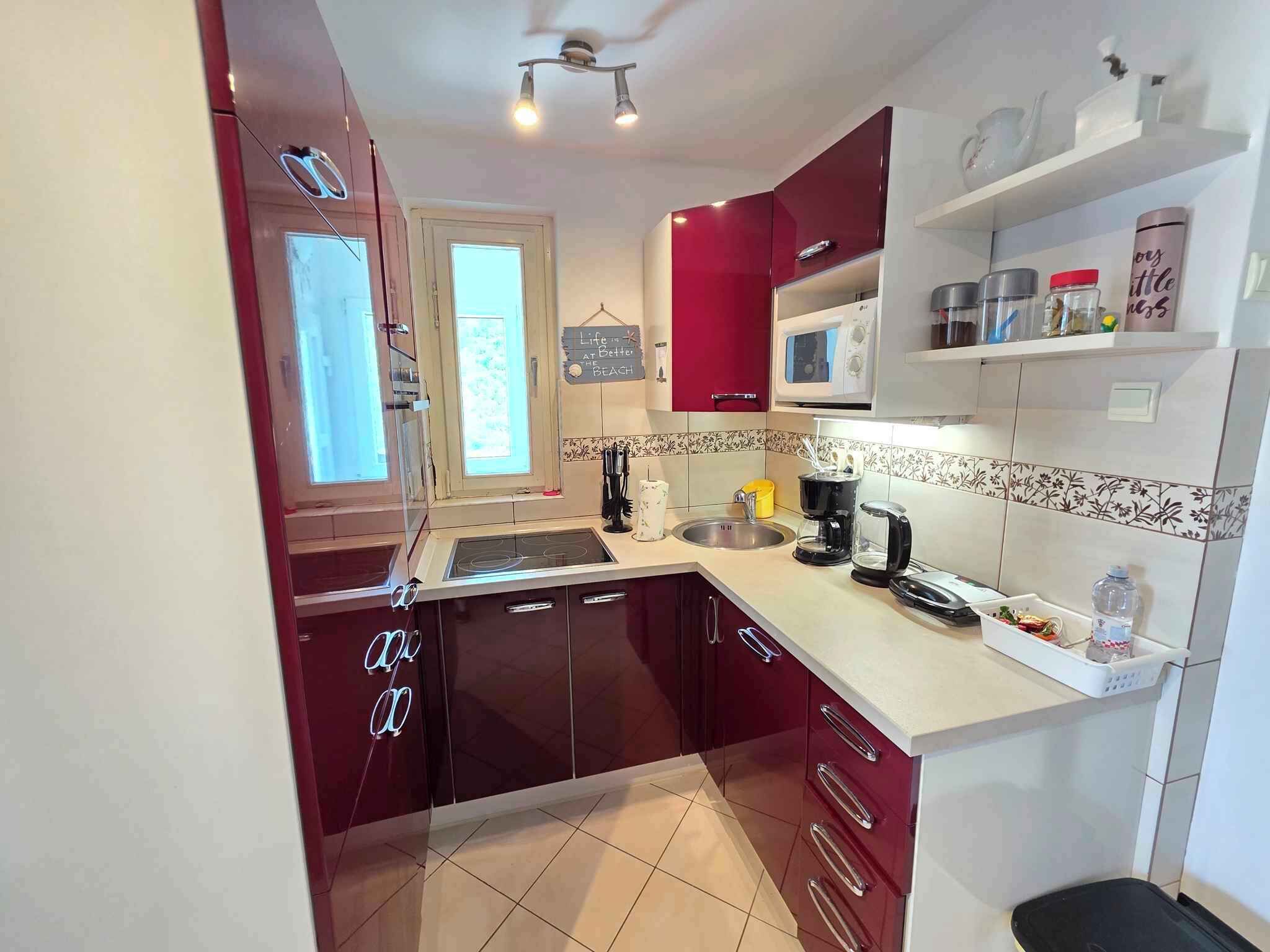 A kitchen with a microwave, sink, and various appliances.