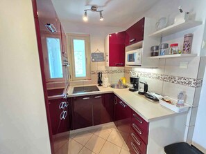A kitchen with a microwave, sink, and various appliances. - Holiday apartment apartment with air conditioning and wifi (Klenovica)