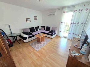 Ein modernes Wohnzimmer mit einer Eckcouch, einem Couchtisch und einem Esstisch.