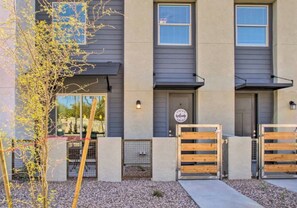 A modern two-story building with a gray exterior, a welcome sign, and a gated entrance. - Modern Farmhouse Mesa Retreat (Mesa)