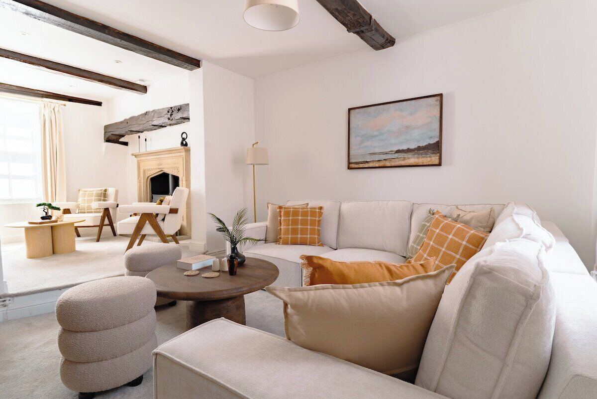 Un salon avec une cheminée, un canapé, une table basse et un tableau au mur.