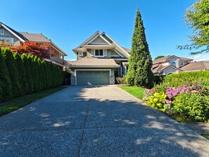 A residential driveway leading to a two-story house with a garage.