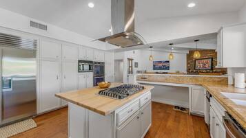 A modern kitchen with white cabinetry, stainless steel appliances, and a central island.