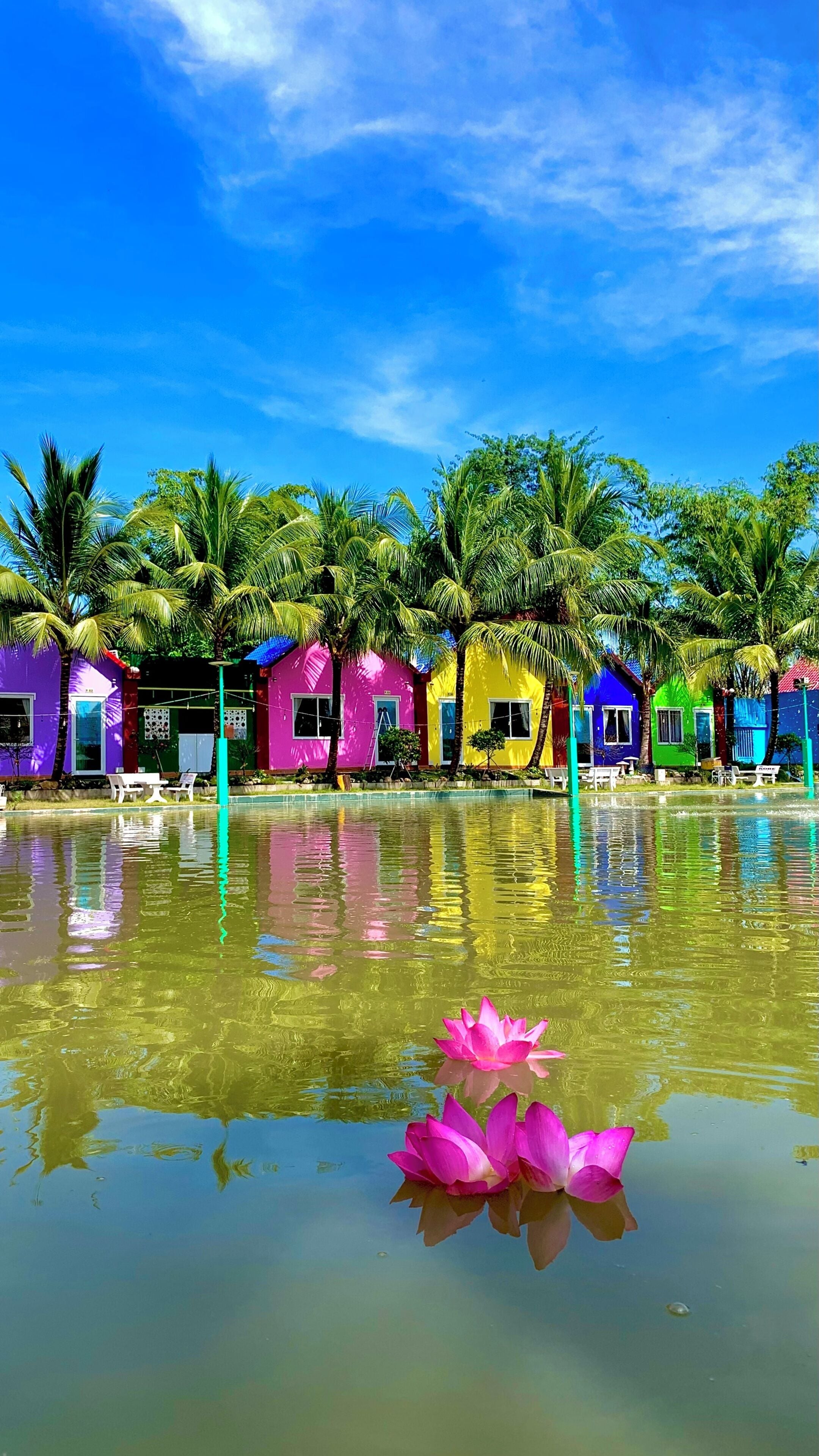 A row of colorful houses with a water body in front, reflecting the structures.