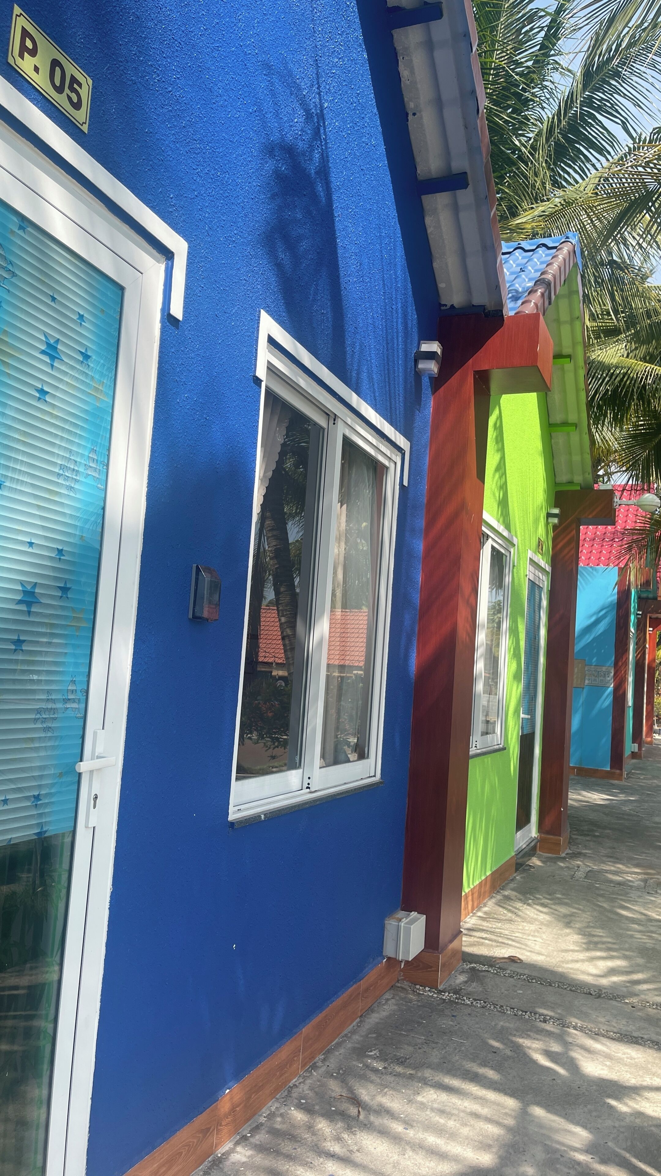 A row of colorful buildings with a blue facade, a visible door, and a window.