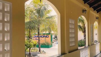 A corridor with arched doorways, a tiled floor, and a view of a building with a sign that reads 'DIAMOND Spa & Sports'.