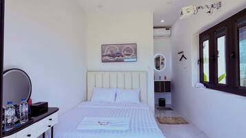 Un dormitorio moderno con cama, mesita de noche y espejo.
