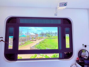 Una habitación con un amplio ventanal que da a un jardín y una casa.