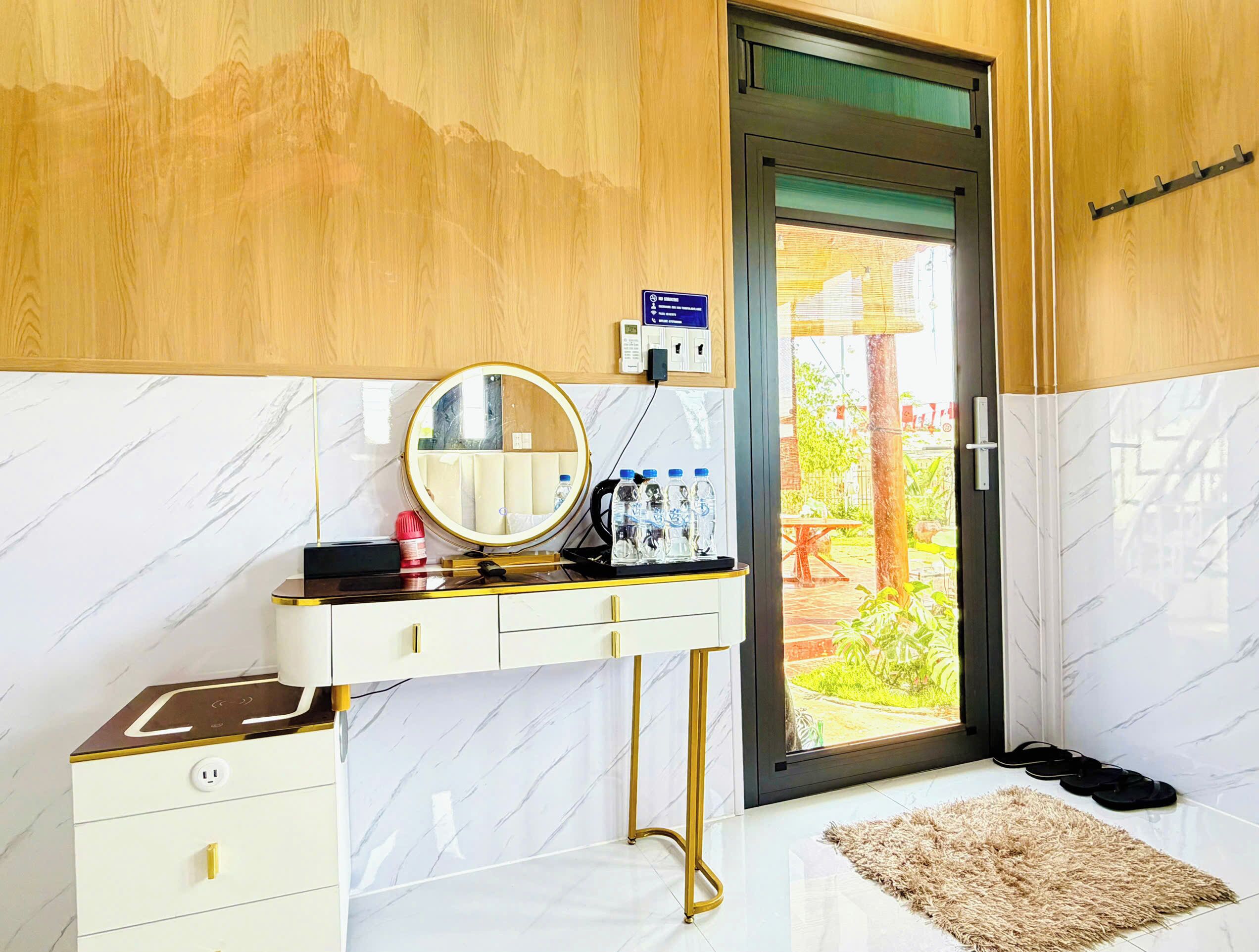 A bathroom with a vanity, mirror, and a view of the outdoors.