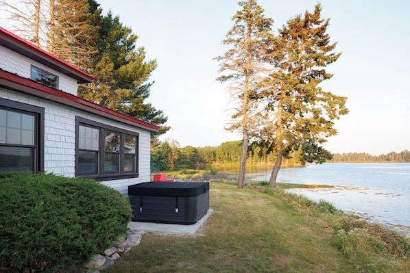 A house with a red roof, large windows, and a black outdoor heater.