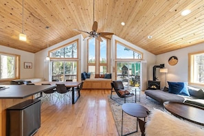 Une pièce spacieuse avec un plafond haut, de grandes fenêtres, une cheminée et un coin salon confortable.