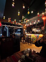 A bar area with hanging lights, a counter, and a view of the outside.