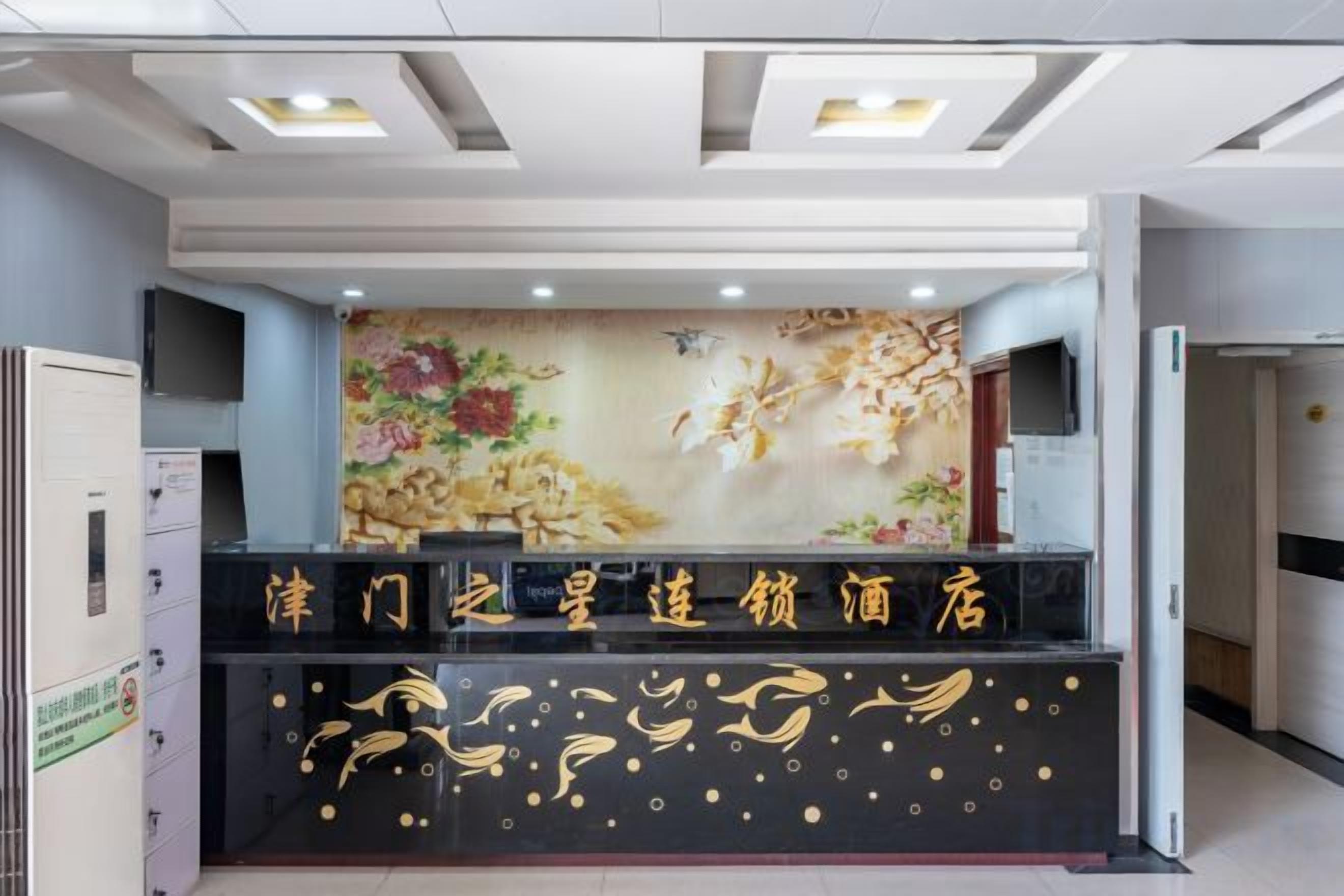 A reception desk with a floral mural and a black counter with gold accents.