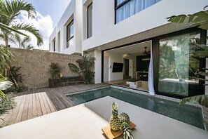 A modern house with a swimming pool, outdoor seating, and tropical plants. - Club Suma Villa 5 Bingin (Pecatu)