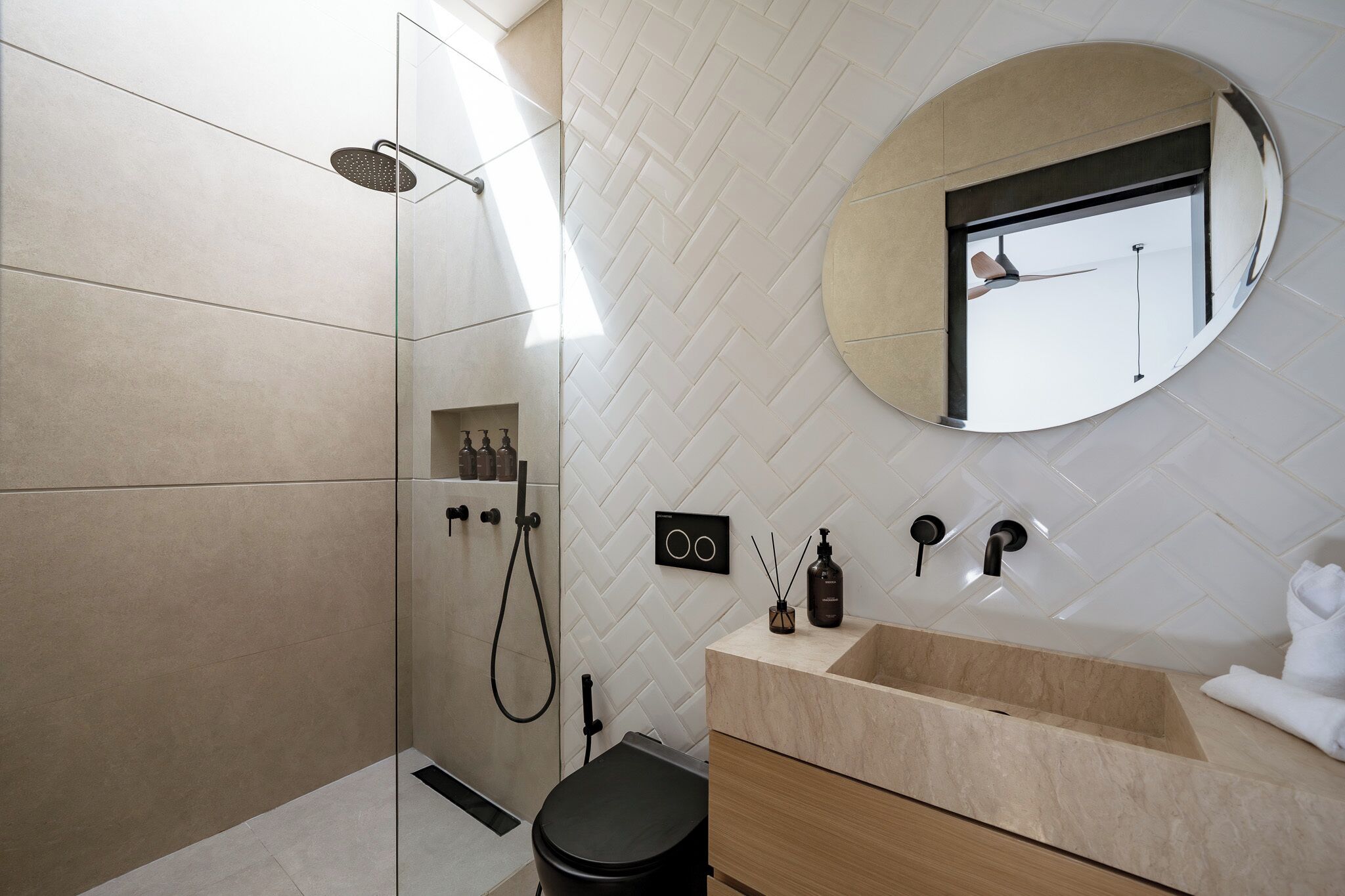 Une salle de bain moderne équipée d’une douche, de toilettes, d’un meuble-lavabo et d’un miroir.