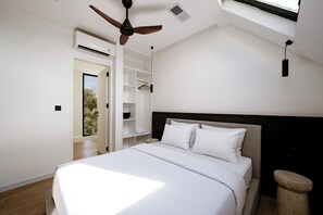 A bedroom with a bed, a ceiling fan, a window, and a built-in wardrobe. - Club Suma Villa 5 Bingin (Pecatu)