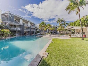 A hotel with a swimming pool, multiple balconies, and palm trees. - Forever Summer at Drift North (Tweed)