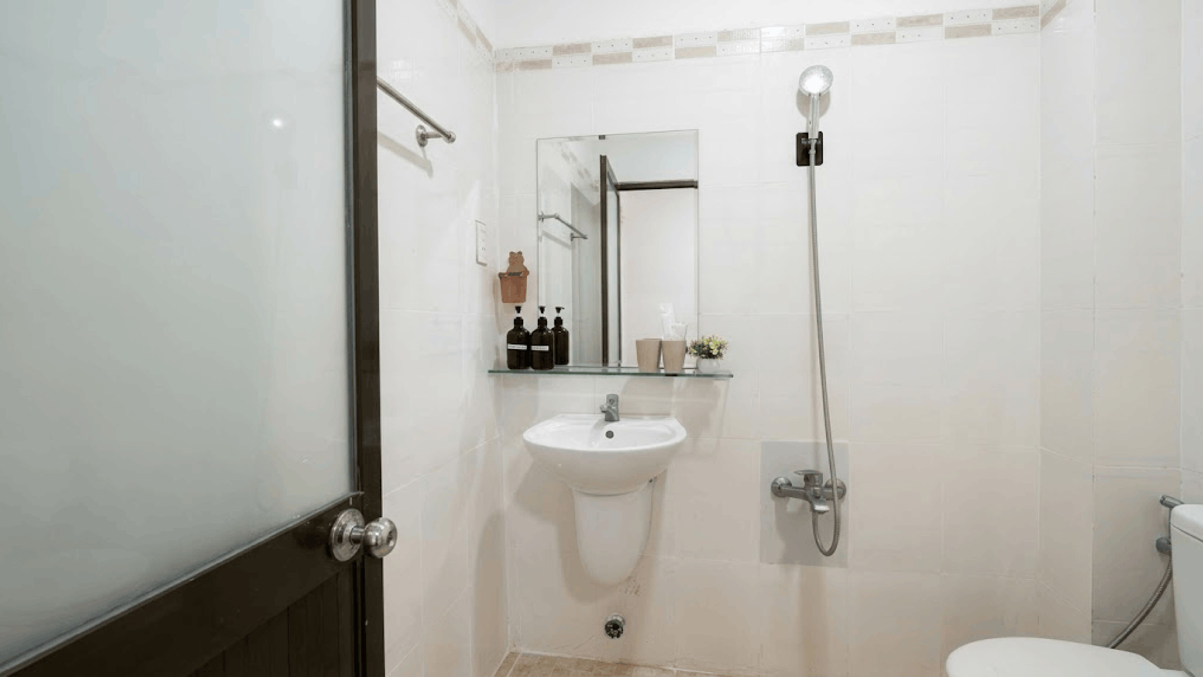 Un baño con inodoro, lavamanos, ducha y espejo.