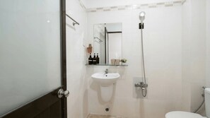 Un baño con inodoro, lavamanos, ducha y espejo.