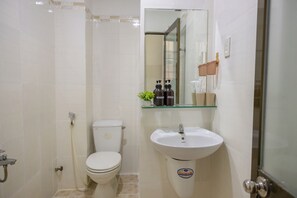 A bathroom with a toilet, sink, and shower. - New Hotel Vung Tau (Ho Chi Minh City)
