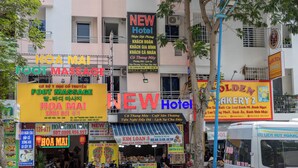 A street view with multiple commercial establishments, including a hotel, a bakery, and a foot massage service. - New Hotel Vung Tau (Ho Chi Minh City)