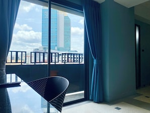 A modern hotel room with a large window, a balcony, and a dining area. - Witz Pop Ratchada (Bangkok)