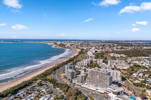 Eine Küstenstadt mit Hotels am Strand, Straßen und blauem Himmel.