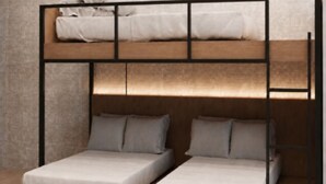 Een stapelbed met houten frame en een onderbed met twee bedden.