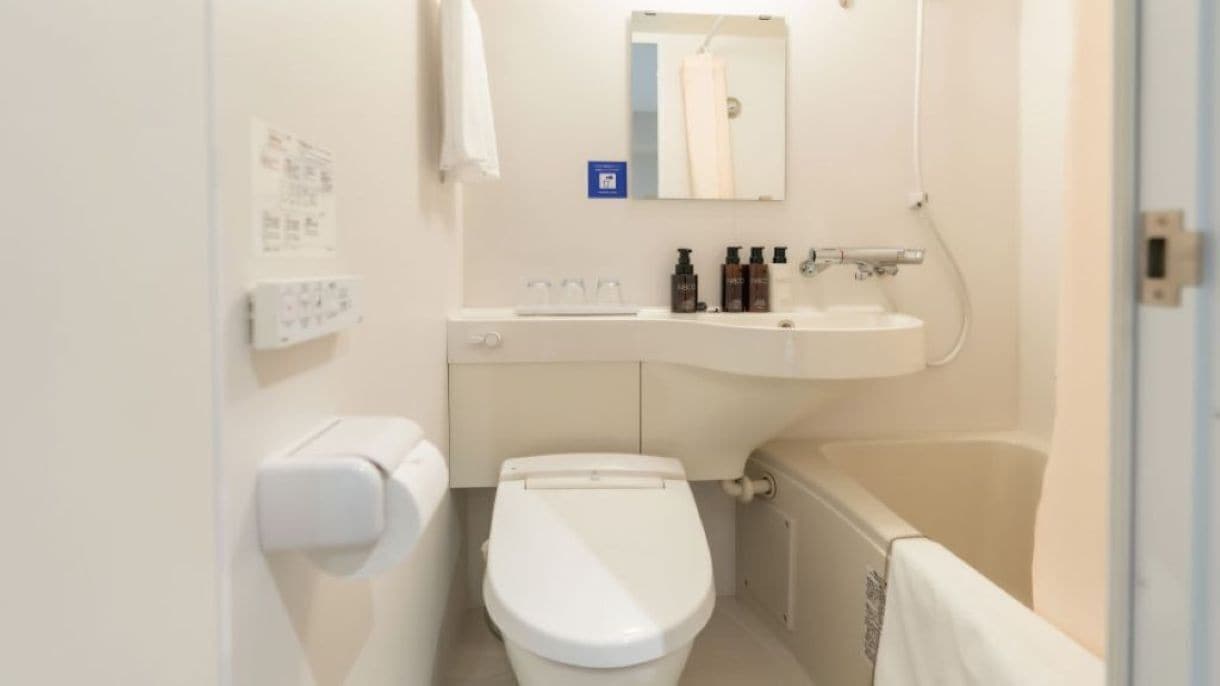 A small, clean bathroom with a toilet, sink, and bathtub.