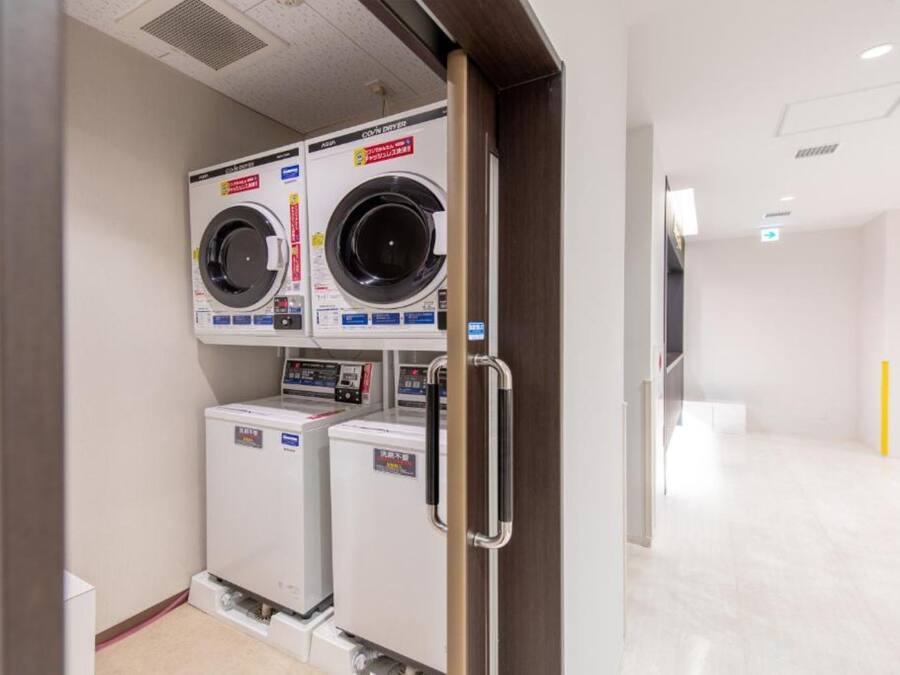 A laundry room with two stacked washing machines and a dryer.