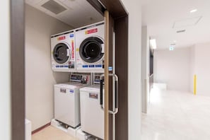 A laundry room with two stacked washing machines and a dryer. - COMPASS HOTEL OSAKA HONMACHI (Osaka)