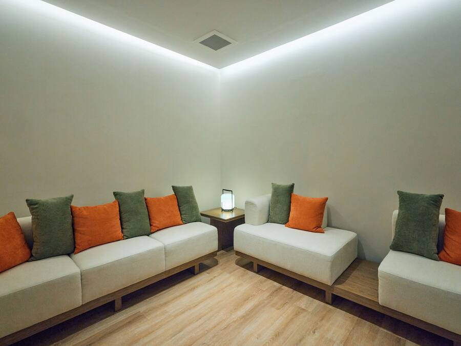 A room with two sofas and a small table, each with multiple cushions.