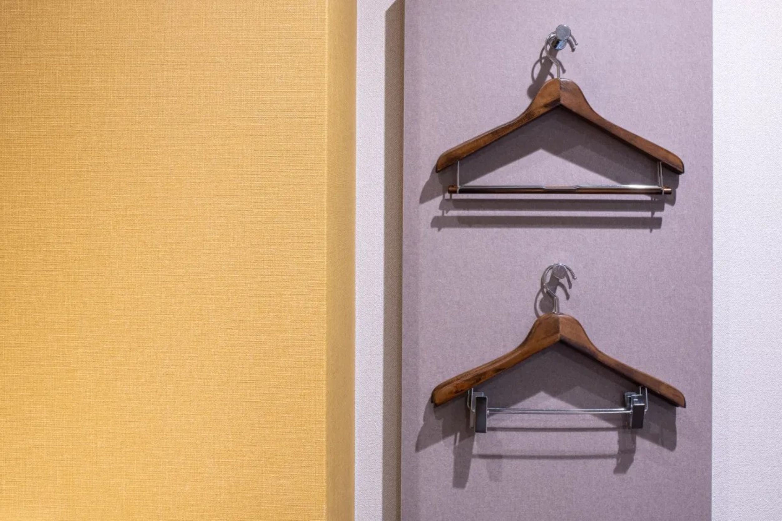 Two wooden hangers mounted on a wall.
