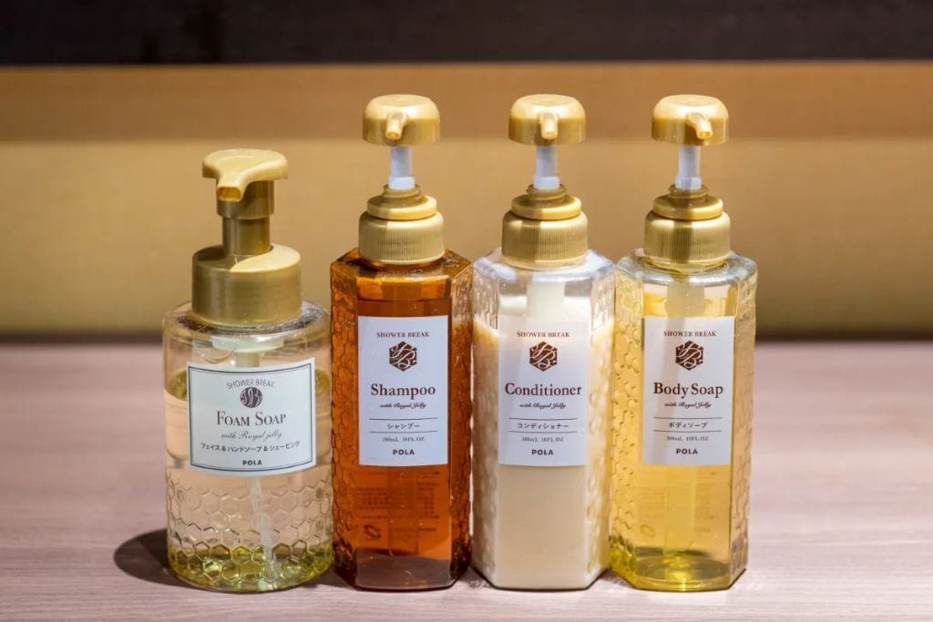 Four bottles of shower products on a shelf.