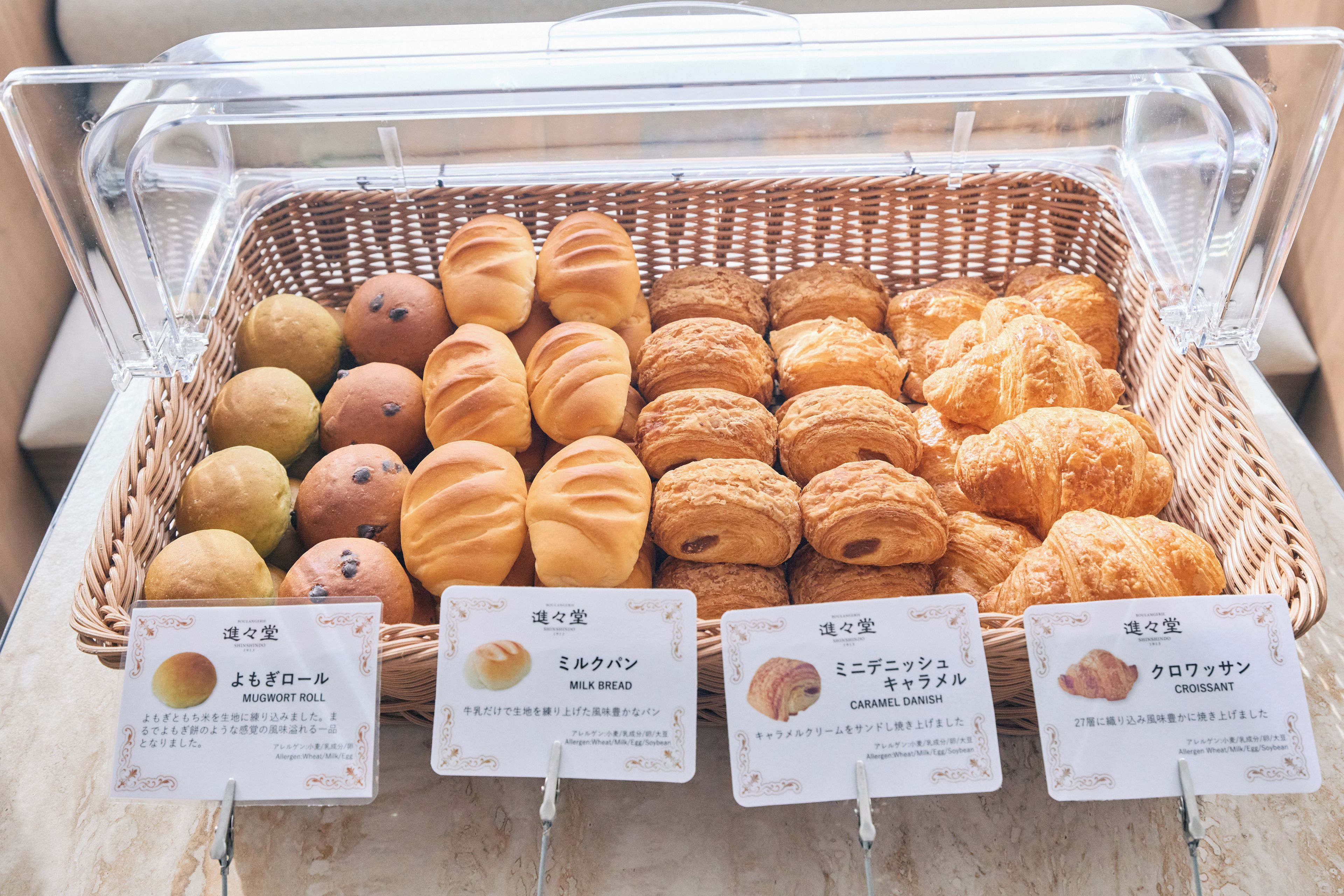 A display of baked goods in a clear plastic container with labels.