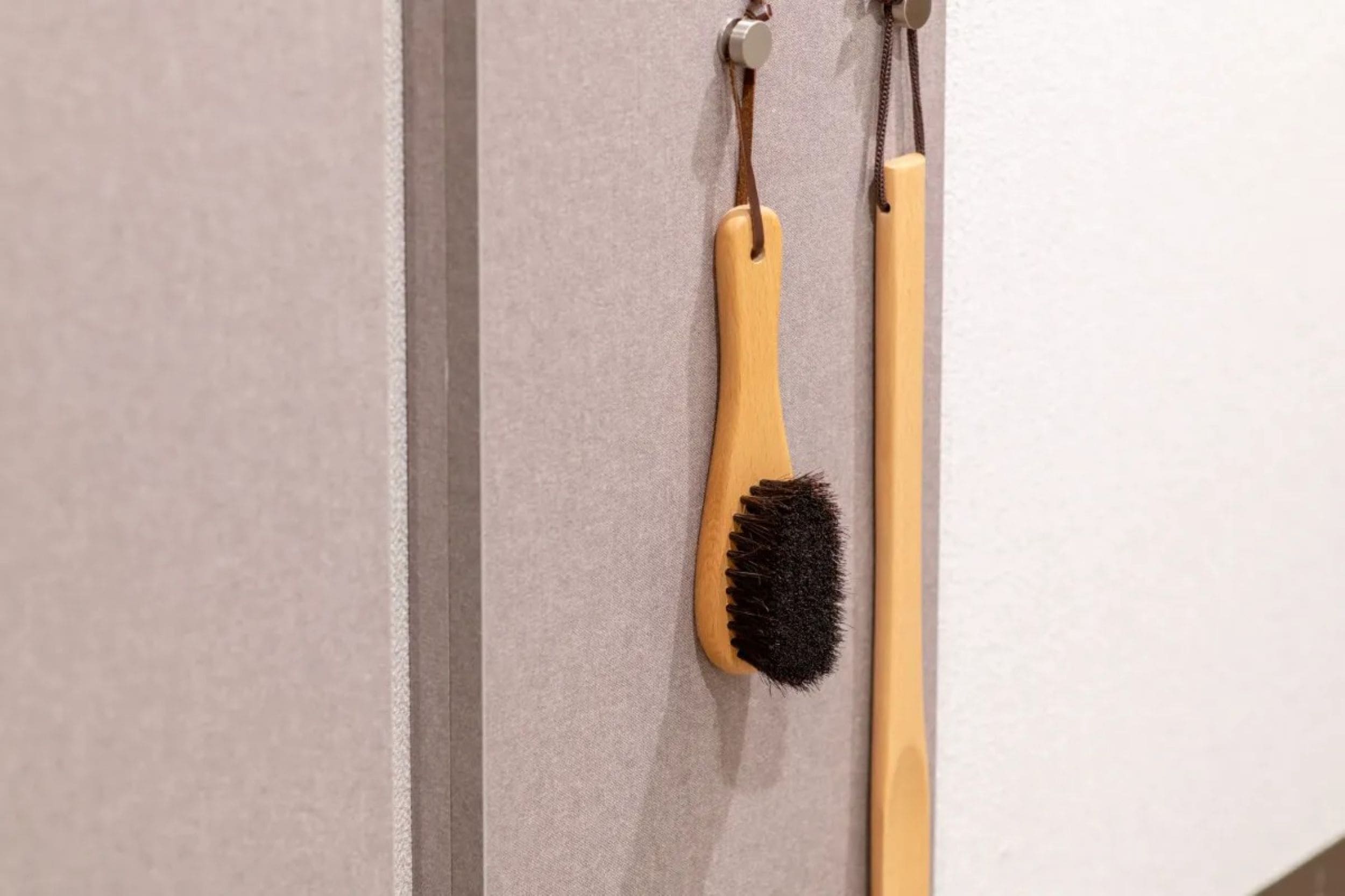 Two brushes hanging on a wall.