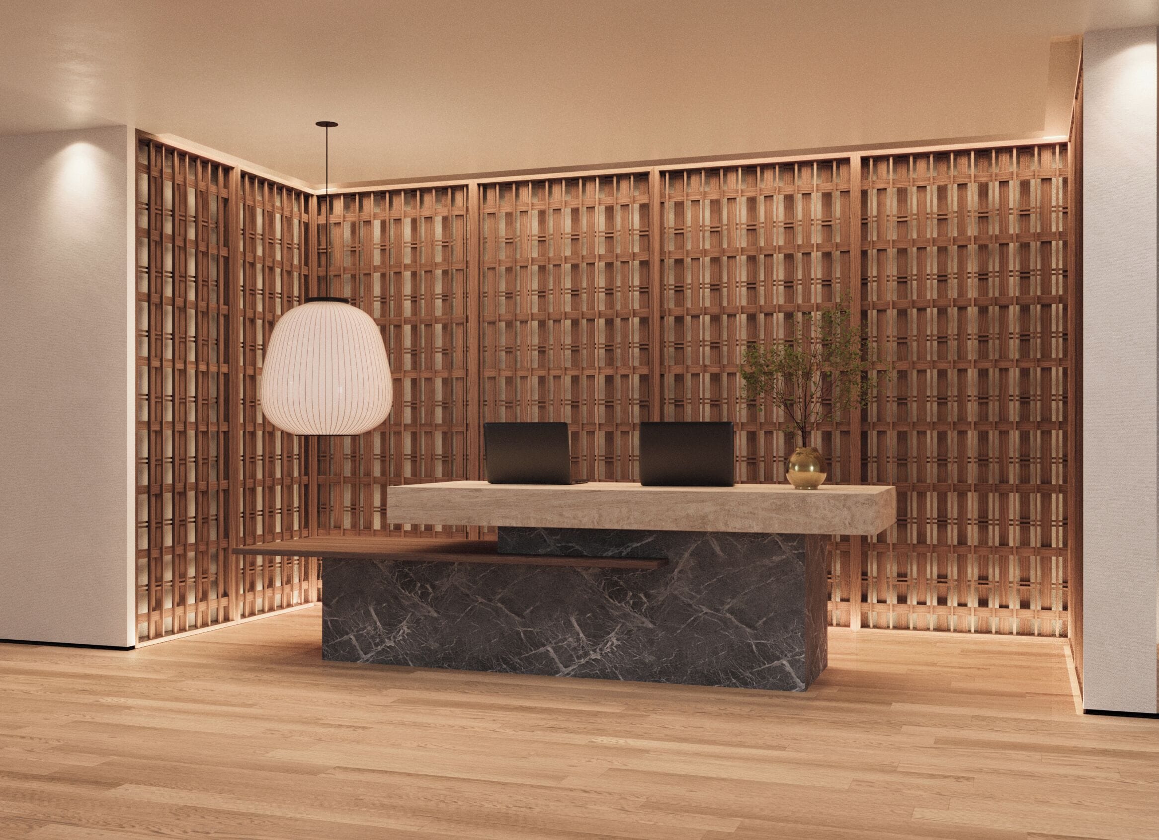 A reception desk with a marble base, two black monitors, and a hanging light fixture.