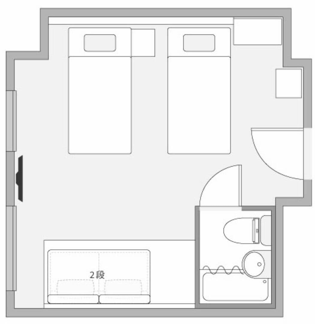 Plano de un cuarto de hotel con una cama, un baño y una pequeña zona de estar.