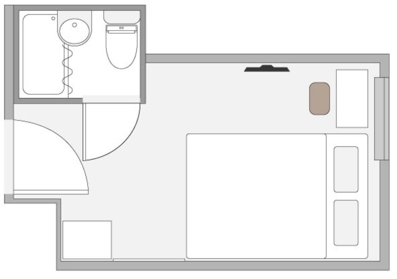 A hotel room layout with a bed, a bathroom, and a small sitting area.
