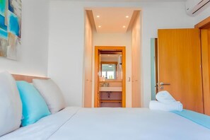 Et hotelværelse med en seng, et badeværelse med et spejl og en trædør.